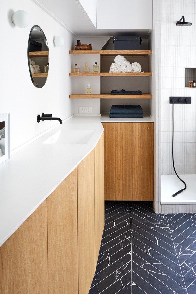 Medium sized contemporary shower room bathroom in Paris with flat-panel cabinets, light wood cabinets, a walk-in shower, white walls, marble flooring, a console sink, solid surface worktops, black floors and a hinged door.