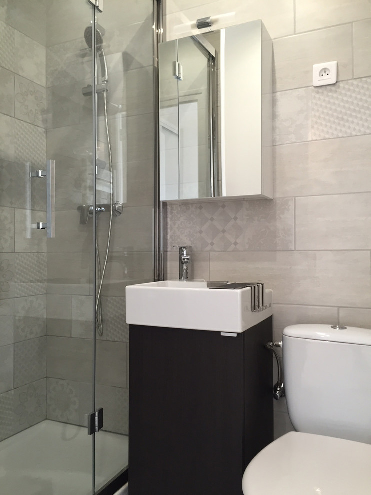 Réalisation d'une salle de bain design avec un carrelage gris.