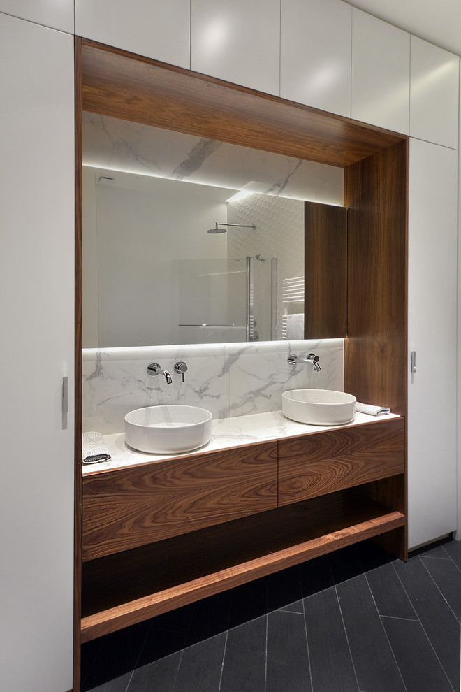 This is an example of a contemporary bathroom in Paris with beaded cabinets, dark wood cabinets, ceramic tiles, white walls, ceramic flooring, a built-in sink, marble worktops, black floors and white worktops.