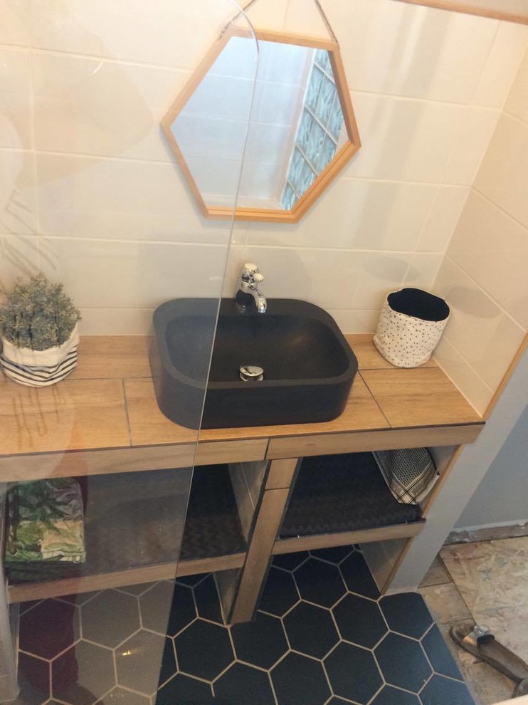 Exemple d'une petite salle d'eau tendance avec une baignoire encastrée, un carrelage blanc, des carreaux de céramique, carreaux de ciment au sol et un sol noir.