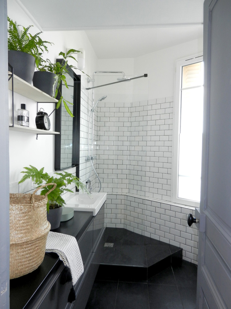 На фото: маленькая ванная комната в современном стиле с душевой кабиной, черным полом, плоскими фасадами, черными фасадами, угловым душем, белой плиткой, плиткой кабанчик, белыми стенами, консольной раковиной, открытым душем и черной столешницей для на участке и в саду с