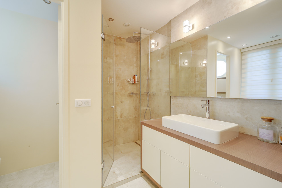 Стильный дизайн: ванная комната среднего размера в современном стиле с плоскими фасадами, белыми фасадами, душем без бортиков, бежевой плиткой, мраморной плиткой, душевой кабиной, раковиной с несколькими смесителями и душем с распашными дверями - последний тренд