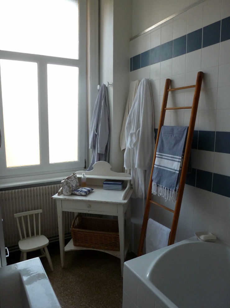 リールにある低価格の中くらいな北欧スタイルのおしゃれなマスターバスルーム (ドロップイン型浴槽、シャワー付き浴槽	、青いタイル、セラミックタイル、白い壁、テラゾーの床、コンソール型シンク) の写真