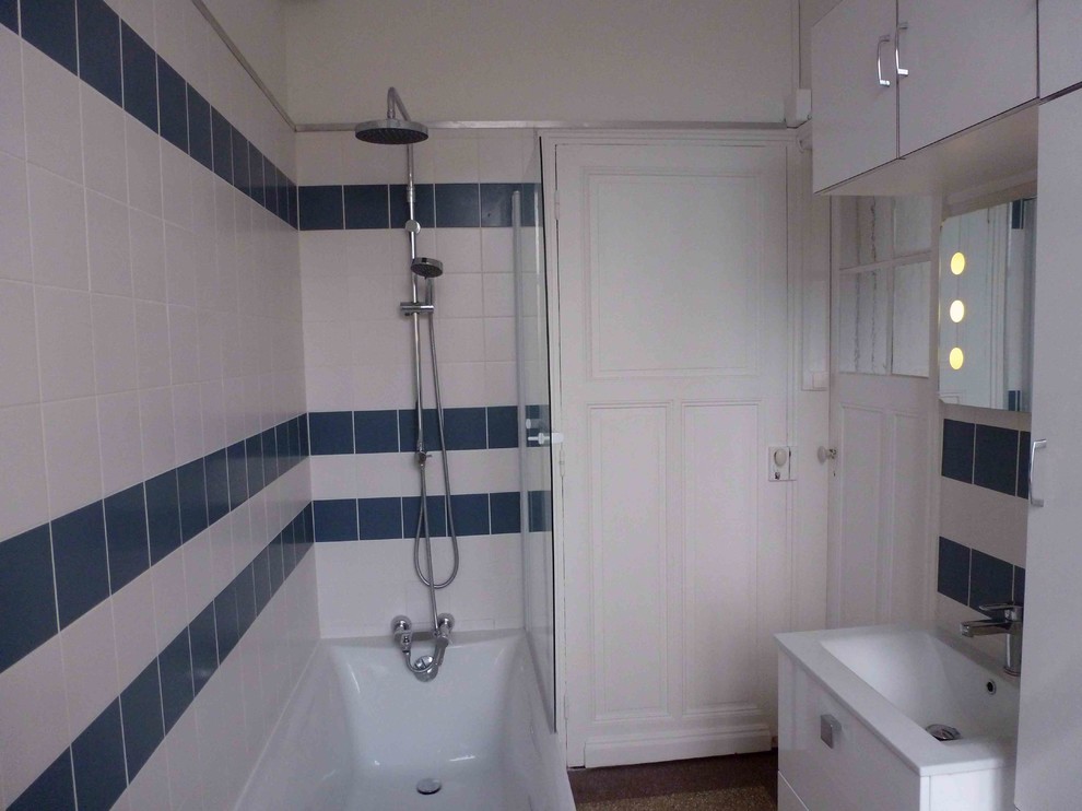 Foto di una stanza da bagno padronale nordica di medie dimensioni con vasca da incasso, vasca/doccia, piastrelle blu, piastrelle in ceramica, pareti bianche, pavimento alla veneziana e lavabo a consolle