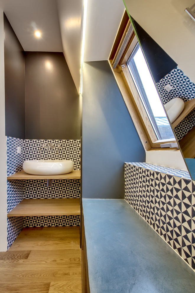 Example of a mid-sized trendy master blue tile and cement tile brown floor and light wood floor bathroom design in Paris with open cabinets, wood countertops, light wood cabinets, an undermount tub, a two-piece toilet, blue walls and a trough sink