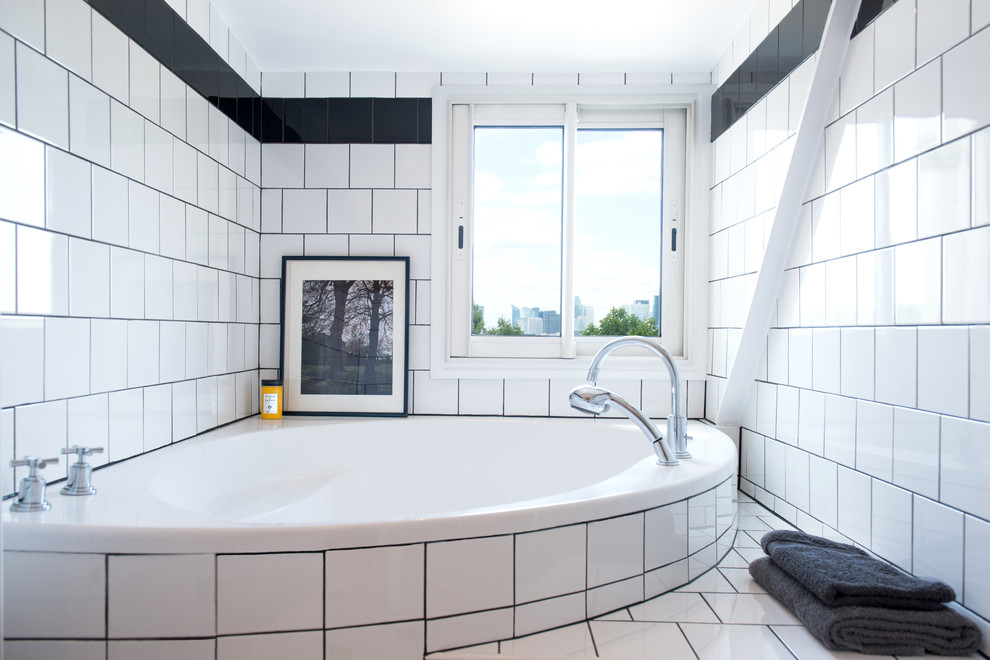 Aménagement d'une salle de bain principale classique avec une baignoire encastrée, un carrelage blanc, un carrelage noir, un mur blanc et un sol en bois brun.