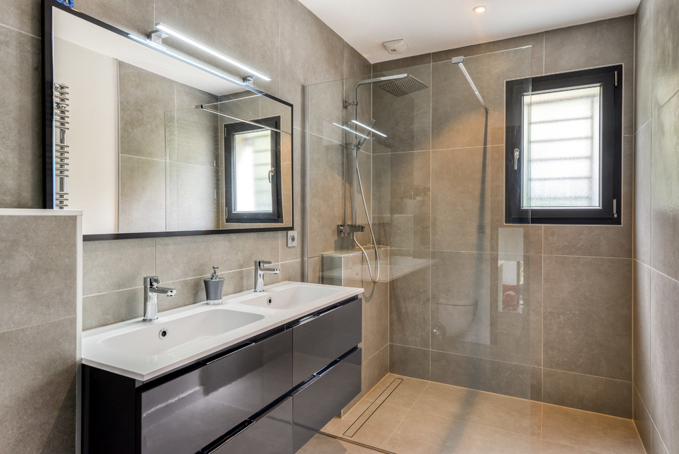 Foto di una stanza da bagno con doccia minimal con ante lisce, ante nere, doccia a filo pavimento, piastrelle grigie, lavabo integrato, pavimento grigio, doccia aperta e top bianco