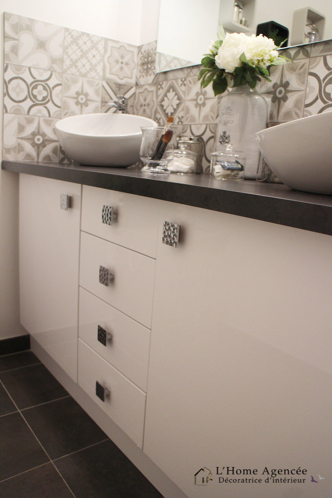 Exemple d'une salle d'eau chic de taille moyenne avec une baignoire encastrée, un carrelage noir et blanc, un carrelage gris, des carreaux de béton, un mur blanc, un sol en carrelage de céramique, un plan de toilette en béton et une vasque.