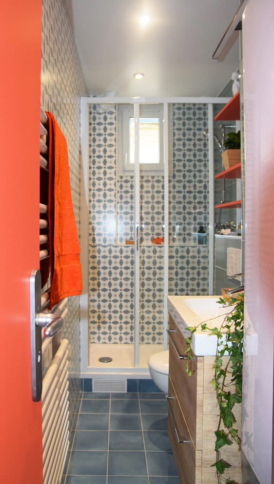 Photo of a small modern ensuite bathroom in Paris with a wall mounted toilet, blue tiles, ceramic tiles, multi-coloured walls, ceramic flooring, an integrated sink, blue floors and a sliding door.