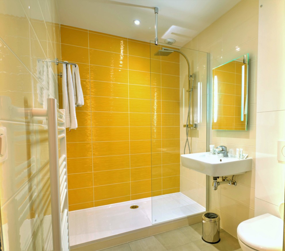 Источник вдохновения для домашнего уюта: ванная комната среднего размера в современном стиле с открытым душем, инсталляцией, керамической плиткой, желтыми стенами, полом из керамической плитки, душевой кабиной, подвесной раковиной, серым полом, открытым душем и белой столешницей