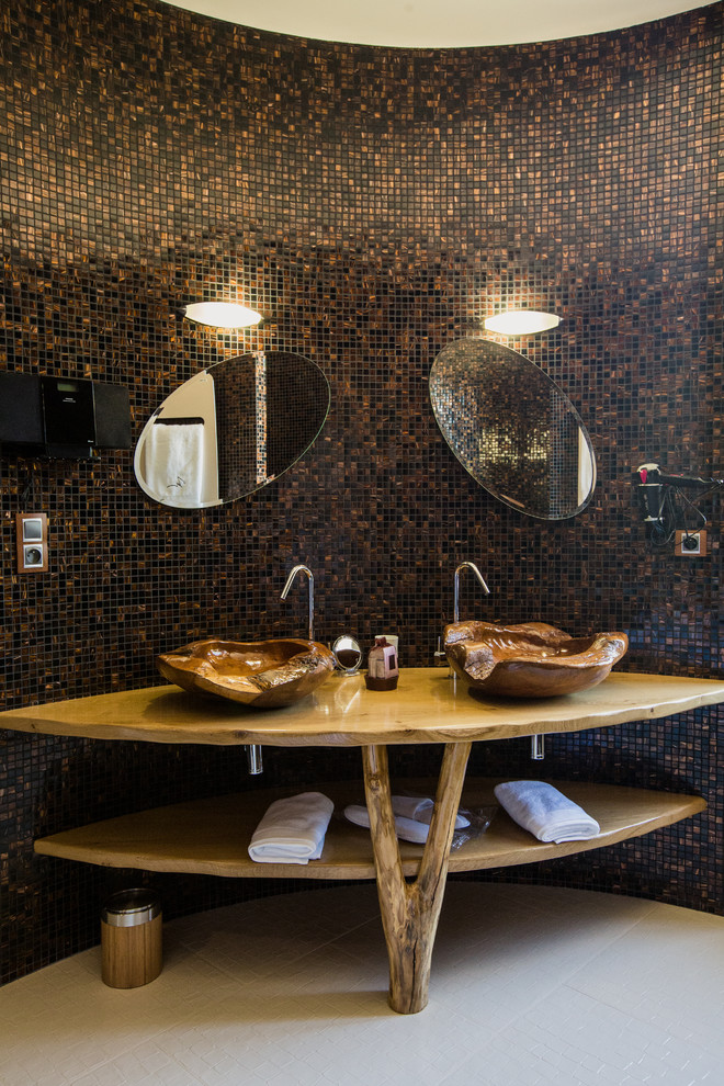 Photo of a large world-inspired shower room bathroom in Strasbourg with open cabinets, medium wood cabinets, brown tiles, black tiles, mosaic tiles, ceramic flooring, a vessel sink and wooden worktops.