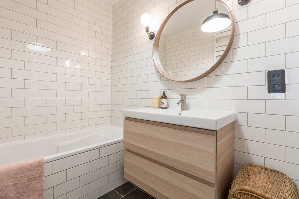 Foto di una piccola stanza da bagno padronale moderna con vasca sottopiano, piastrelle bianche, piastrelle in ceramica, pareti bianche, pavimento con piastrelle in ceramica, lavabo rettangolare e pavimento nero