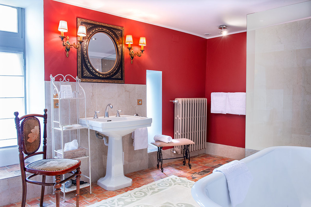 Inspiration för stora klassiska en-suite badrum, med öppna hyllor, ett badkar med tassar, en kantlös dusch, en toalettstol med separat cisternkåpa, beige kakel, marmorkakel, röda väggar, klinkergolv i terrakotta, ett avlångt handfat och orange golv
