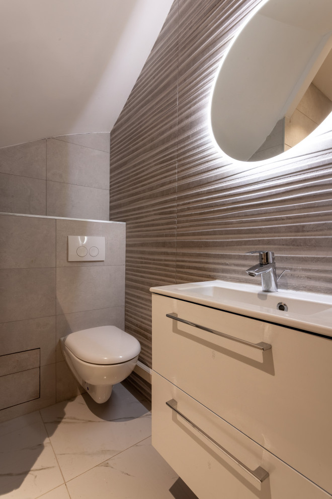 Bild på ett mellanstort funkis vit vitt badrum med dusch, med släta luckor, vita skåp, en vägghängd toalettstol, grå kakel, porslinskakel, klinkergolv i porslin, ett integrerad handfat och grått golv