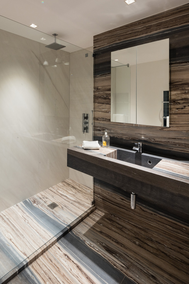 Immagine di una stanza da bagno con doccia design con doccia a filo pavimento, lavabo sospeso e top in marmo