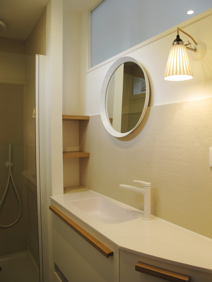 Foto på ett litet funkis badrum med dusch, med ett konsol handfat, luckor med profilerade fronter, vita skåp, en dusch i en alkov, beige kakel, keramikplattor och vinylgolv