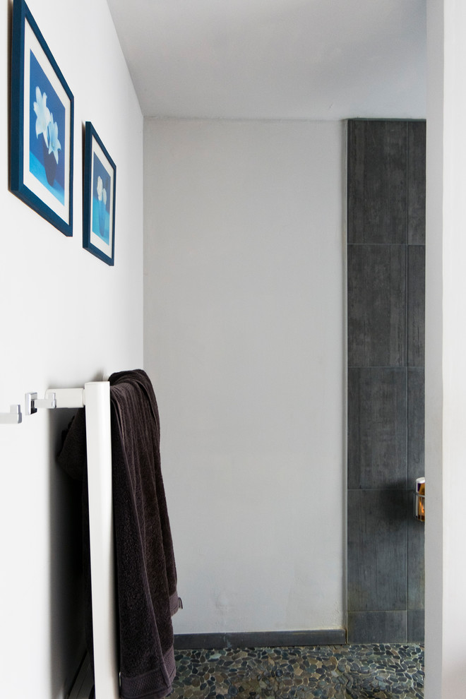 Idee per una stanza da bagno con doccia minimal di medie dimensioni con doccia aperta, piastrelle grigie, piastrelle in ceramica, pareti bianche, pavimento con piastrelle di ciottoli, lavabo integrato, pavimento grigio e doccia aperta