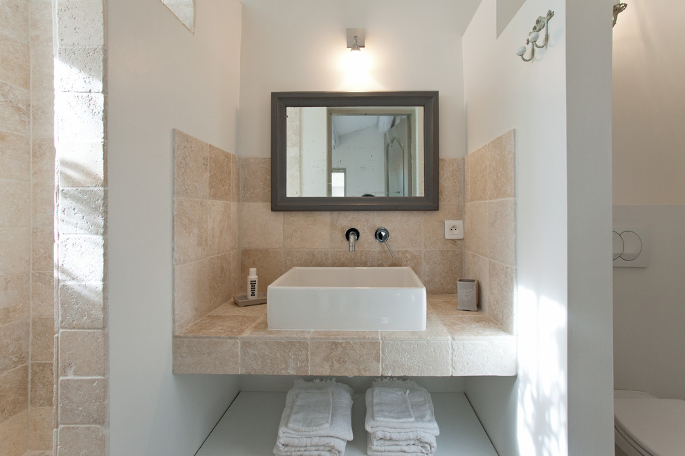 Photo of a small mediterranean ensuite bathroom in Marseille with open cabinets, a walk-in shower, beige tiles, stone tiles, beige walls, a vessel sink and an open shower.