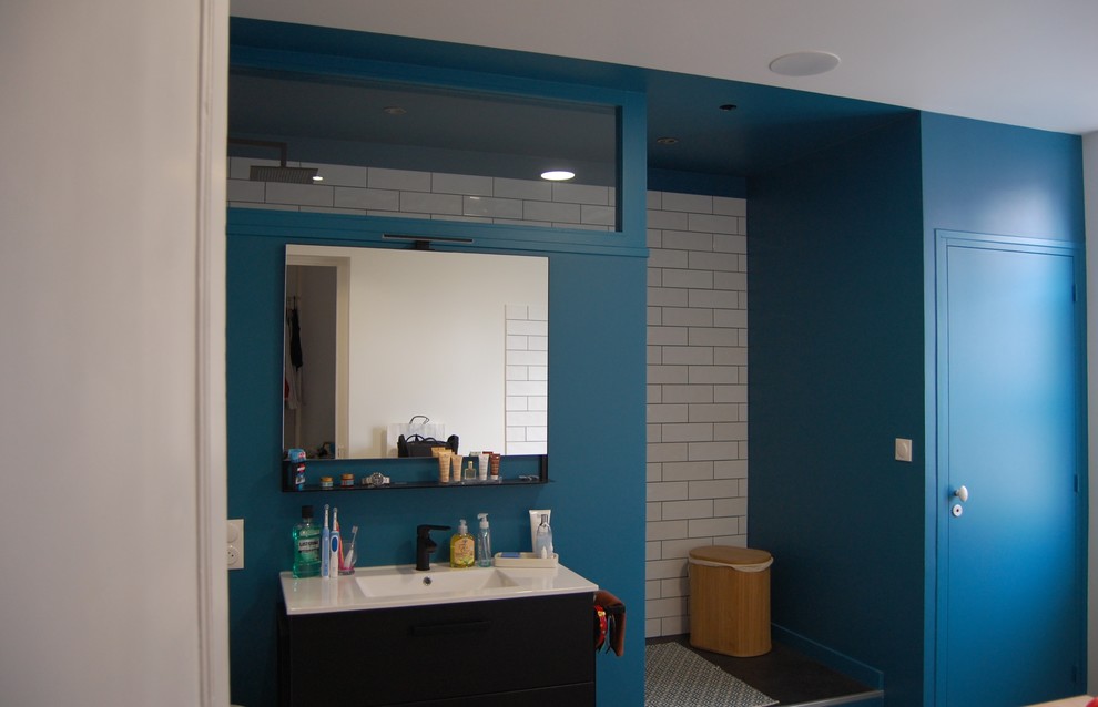 Photo of a large contemporary ensuite bathroom in Paris with a submerged bath, a walk-in shower, a wall mounted toilet, white tiles, ceramic tiles, blue walls, dark hardwood flooring, a console sink, an open shower, open cabinets, brown floors and white worktops.
