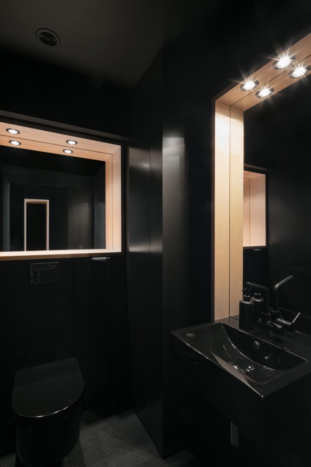 Inspiration pour une salle d'eau design de taille moyenne avec un placard à porte plane, des portes de placard noires, une douche d'angle, WC suspendus, un mur noir, un plan vasque, un plan de toilette en surface solide, un sol noir, une cabine de douche à porte battante et un plan de toilette noir.