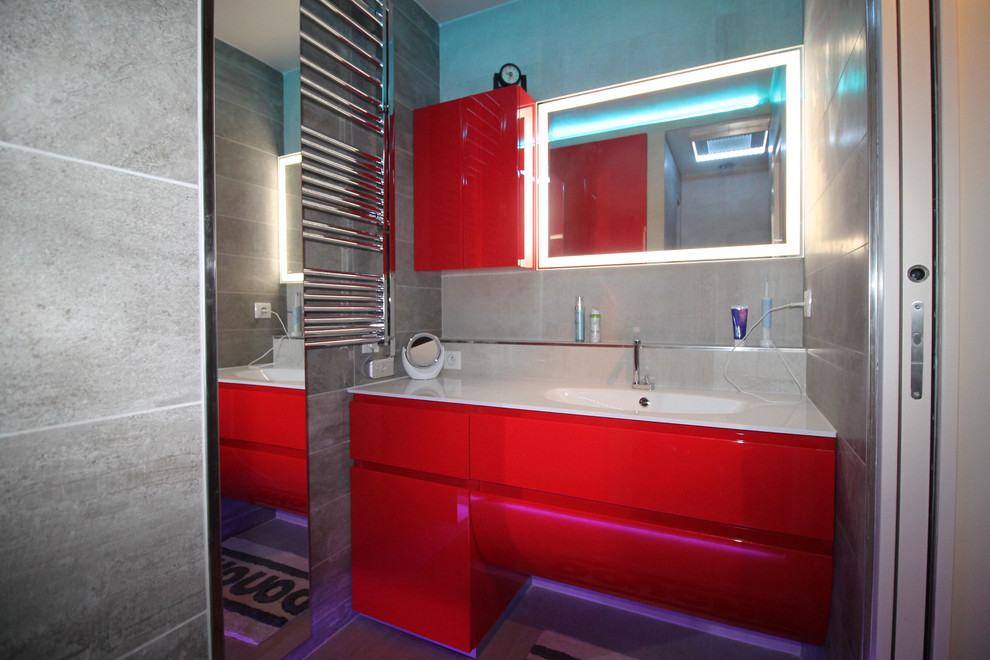 Exemple d'une salle d'eau tendance de taille moyenne avec un placard à porte plane, des portes de placard rouges, une douche à l'italienne, un carrelage gris, un mur gris, un sol en carrelage de céramique et un lavabo intégré.