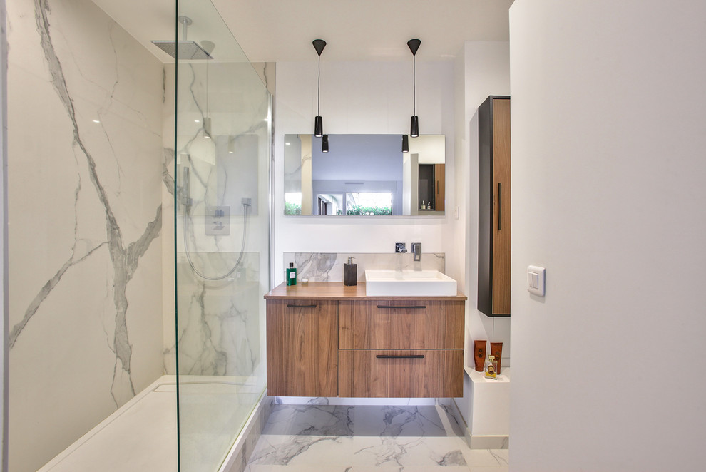 Immagine di una stanza da bagno con doccia minimalista di medie dimensioni con doccia ad angolo, piastrelle di marmo, pavimento in marmo, lavabo integrato e doccia aperta