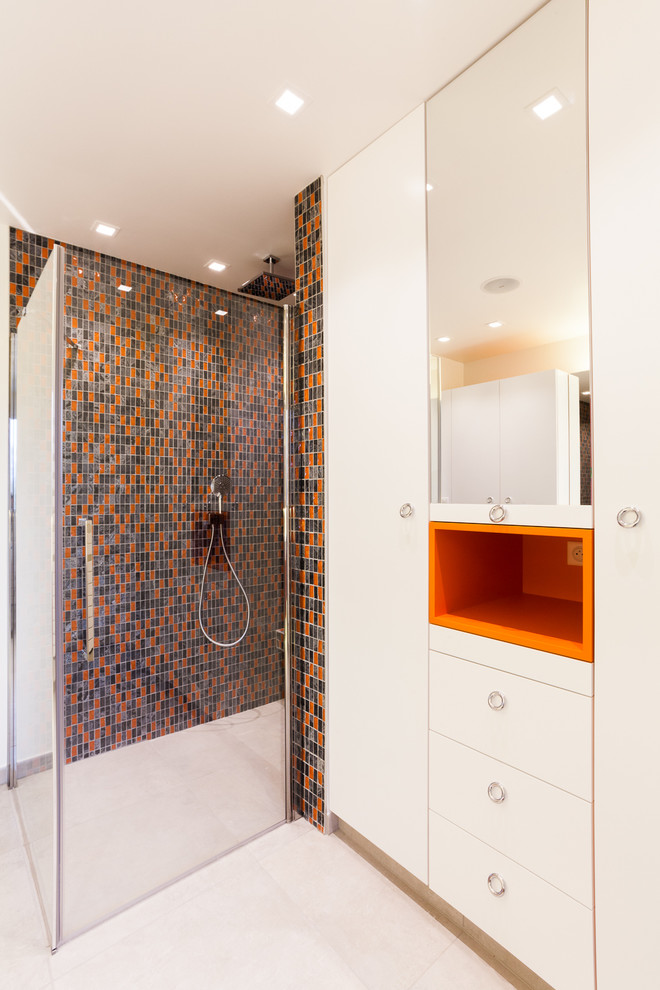 Cette photo montre une salle d'eau rétro avec des portes de placard blanches, une douche à l'italienne, WC séparés, un carrelage gris, un carrelage noir, un carrelage orange, mosaïque et un mur blanc.
