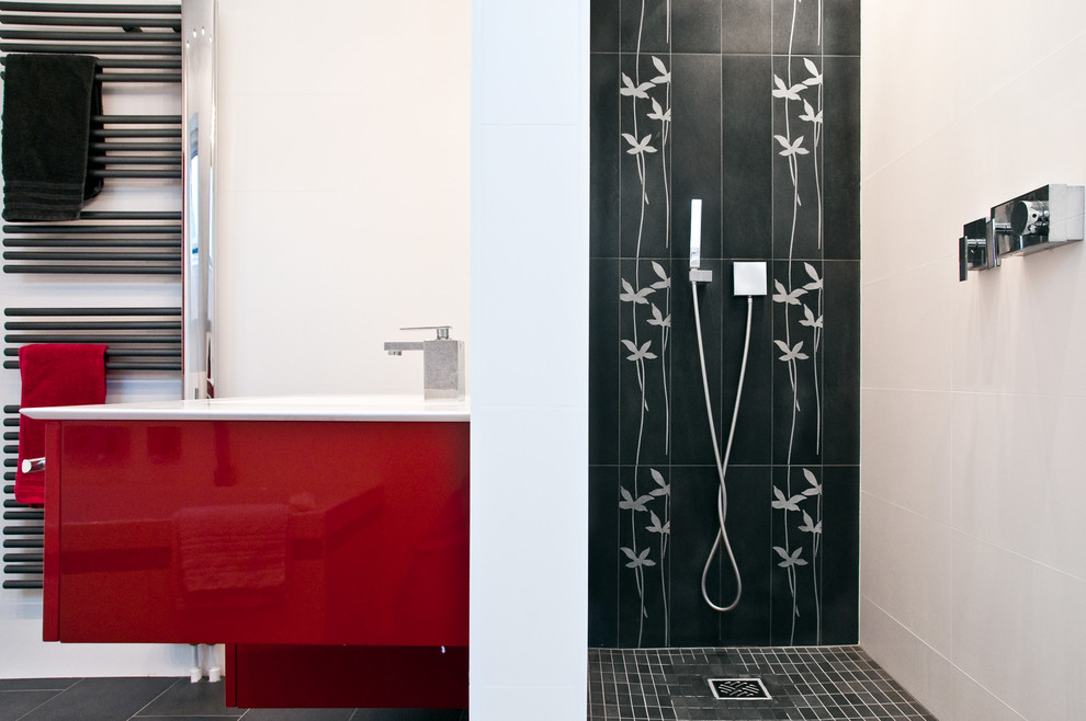Aménagement d'une grande salle de bain principale moderne avec des portes de placard rouges, une douche ouverte, un carrelage noir et blanc, un mur blanc, carreaux de ciment au sol, un lavabo encastré, un sol noir et aucune cabine.