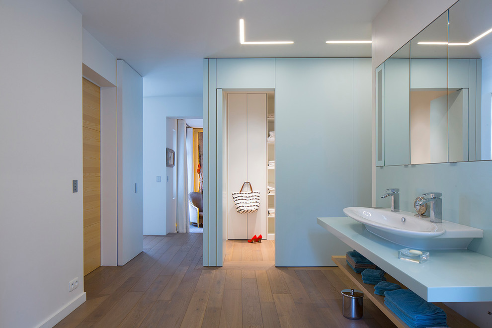 Idee per una grande stanza da bagno padronale minimal con pavimento in legno massello medio, lavabo rettangolare, pavimento marrone, nessun'anta e pareti bianche