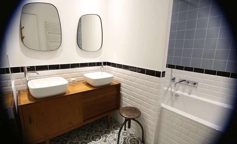 Cette photo montre une petite salle de bain principale tendance avec un sol en carrelage de céramique, une vasque, un plan de toilette en bois, un sol multicolore, un placard à porte affleurante et une baignoire encastrée.