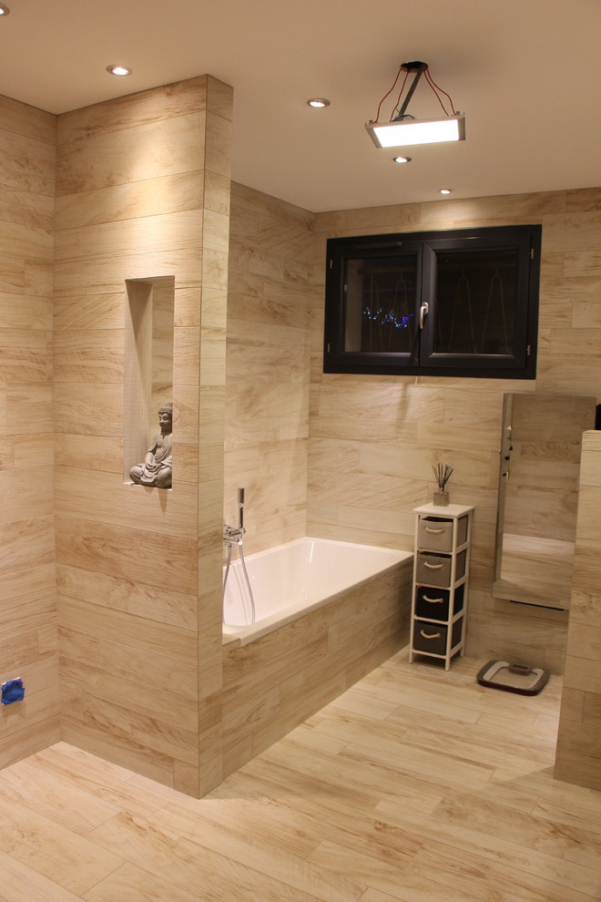 Modern inredning av ett mellanstort badrum med dusch, med en kantlös dusch, en vägghängd toalettstol, beige kakel, keramikplattor, beige väggar, klinkergolv i keramik, ett väggmonterat handfat och kaklad bänkskiva