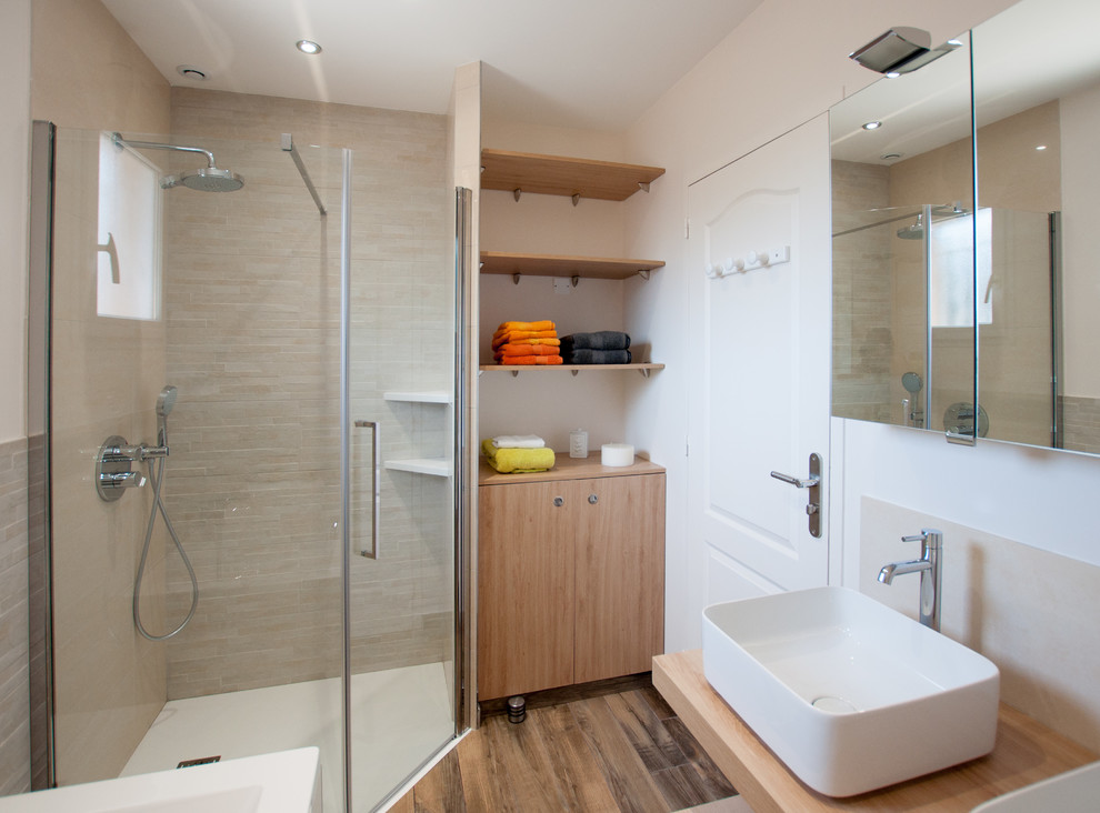 Réalisation d'une petite salle de bain principale design en bois clair avec une douche à l'italienne, un carrelage beige, un mur blanc, un sol en bois brun, un lavabo posé, un plan de toilette en bois et une cabine de douche à porte battante.