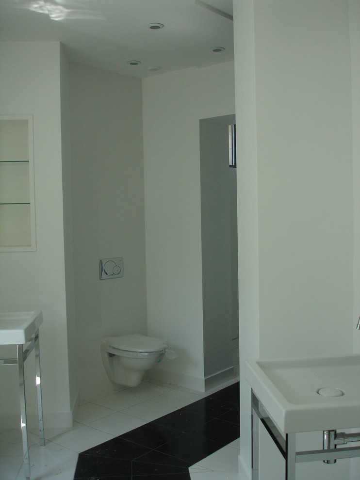 Cette image montre une grande douche en alcôve principale design avec un lavabo de ferme, une baignoire d'angle, WC suspendus, un carrelage noir et blanc et un mur blanc.