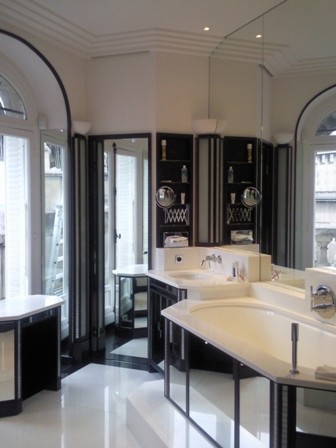 Cette image montre une grande douche en alcôve principale minimaliste avec une baignoire encastrée, WC séparés, un carrelage noir et blanc, mosaïque, un mur blanc, un lavabo encastré, un plan de toilette en marbre, un placard à porte affleurante et un sol en marbre.