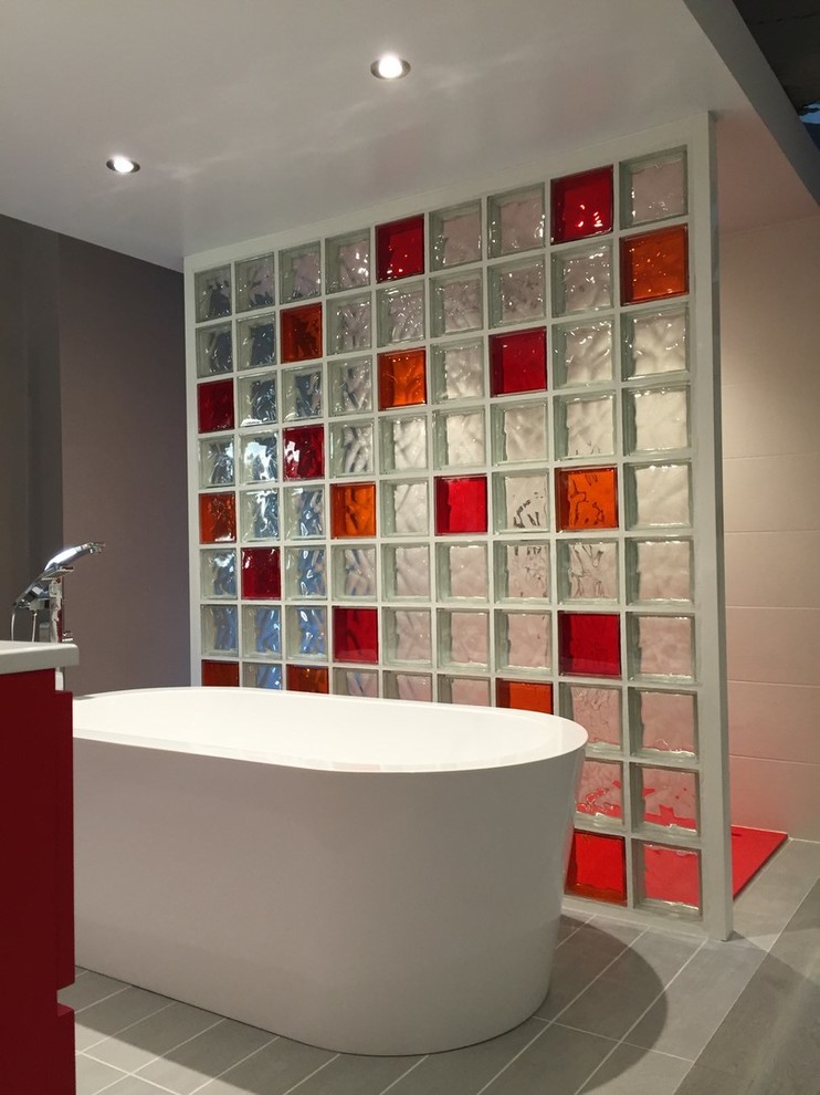 This is an example of an expansive modern ensuite bathroom in Lyon with a built-in bath, a walk-in shower, white tiles, glass tiles, red walls, a trough sink, solid surface worktops, grey floors and an open shower.