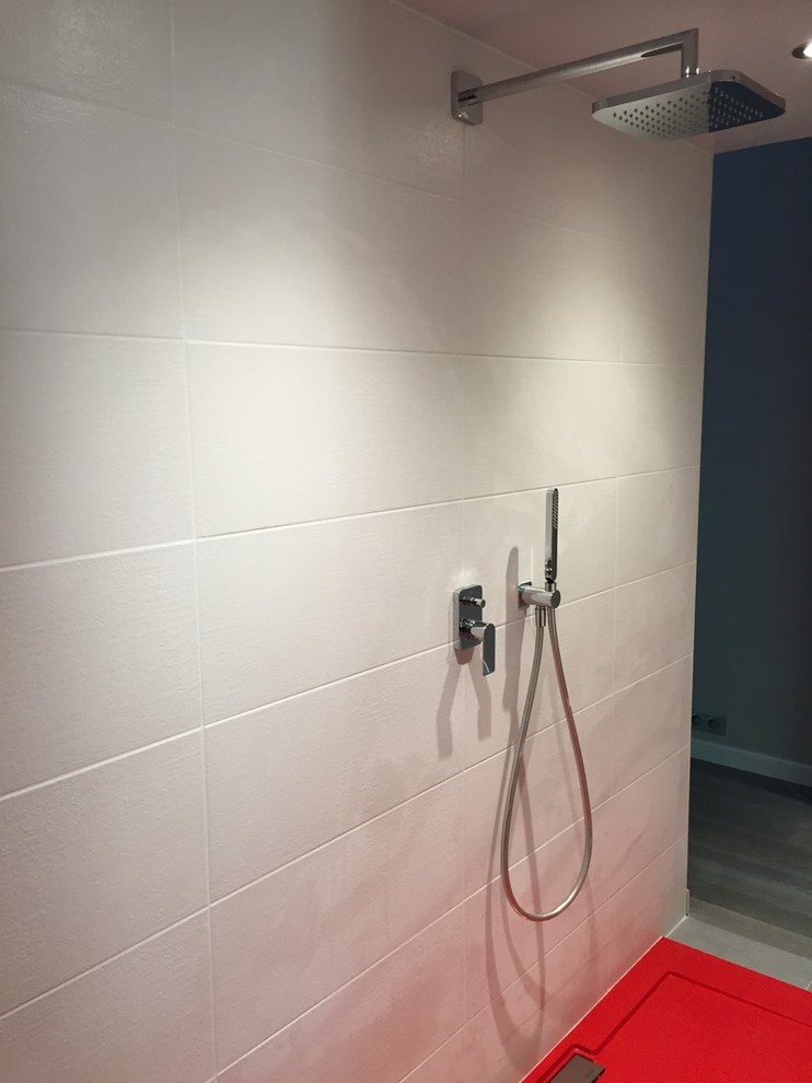 Idée de décoration pour une très grande salle de bain principale minimaliste avec une baignoire posée, une douche ouverte, un carrelage blanc, un carrelage en pâte de verre, un mur rouge, une grande vasque, un plan de toilette en surface solide, un sol gris et aucune cabine.