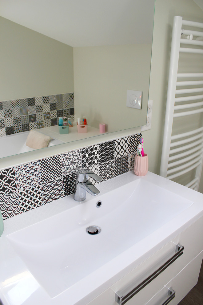 Exemple d'une petite salle de bain tendance pour enfant avec des portes de placard blanches, une baignoire encastrée, un espace douche bain, WC suspendus, un carrelage noir et blanc, des carreaux en terre cuite, un mur vert, sol en stratifié, un lavabo intégré et aucune cabine.