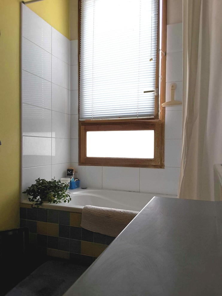 Exempel på ett mellanstort modernt badrum för barn, med luckor med glaspanel, vita skåp, ett undermonterat badkar, en vägghängd toalettstol, flerfärgad kakel, keramikplattor, gula väggar, mörkt trägolv, ett nedsänkt handfat och laminatbänkskiva