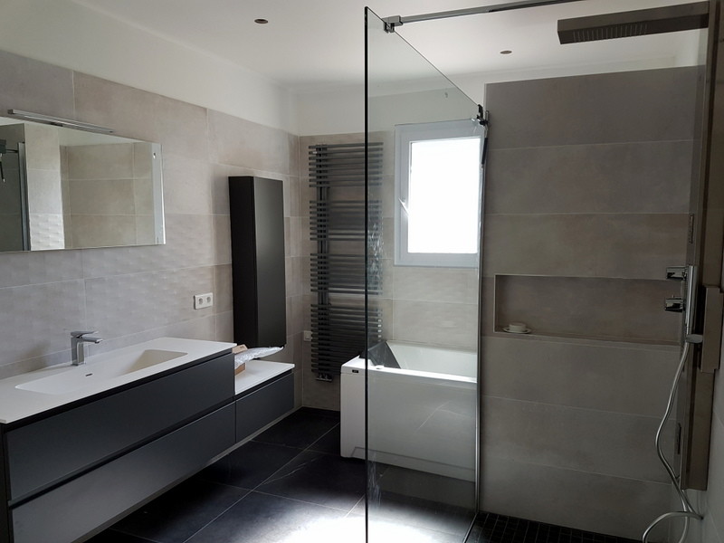 Modern inredning av ett mellanstort en-suite badrum, med en jacuzzi, en kantlös dusch, grå kakel, keramikplattor, grå väggar och bänkskiva i akrylsten