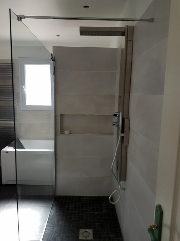 Cette photo montre une salle de bain principale moderne de taille moyenne avec un bain bouillonnant, une douche à l'italienne, un carrelage gris, des carreaux de céramique, un mur gris et un plan de toilette en surface solide.