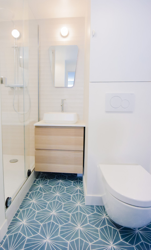 Idée de décoration pour une petite douche en alcôve principale nordique avec un placard à porte plane, des portes de placard beiges, WC suspendus, un carrelage beige, des carreaux de céramique, un mur beige, carreaux de ciment au sol, un lavabo posé, un plan de toilette en stratifié, un sol turquoise, une cabine de douche à porte coulissante, un plan de toilette blanc, buanderie, meuble simple vasque et meuble-lavabo suspendu.