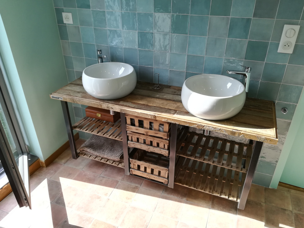 This is an example of a large industrial ensuite bathroom in Angers with open cabinets, distressed cabinets, green tiles, terracotta tiles, green walls, terracotta flooring, a built-in sink, wooden worktops, brown floors, multi-coloured worktops, double sinks and a floating vanity unit.
