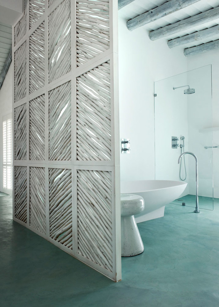 Foto de cuarto de baño principal mediterráneo de tamaño medio con bañera exenta, ducha a ras de suelo, paredes blancas y suelo de cemento