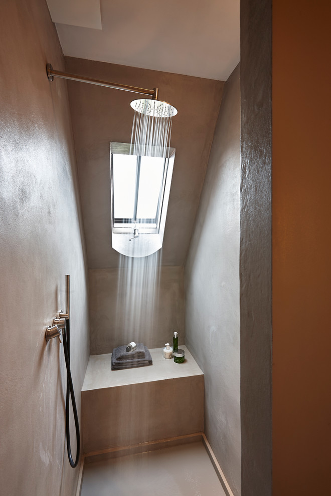 Diseño de cuarto de baño contemporáneo pequeño con ducha empotrada, suelo de cemento, aseo y ducha y paredes marrones