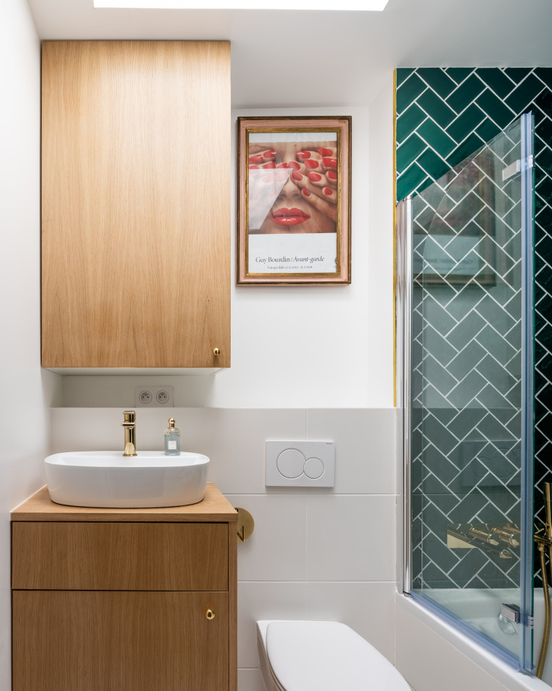 Inredning av ett modernt litet beige beige badrum med dusch, med släta luckor, skåp i mellenmörkt trä, en dusch i en alkov, en vägghängd toalettstol, grå kakel, porslinskakel, vita väggar, ett fristående handfat och träbänkskiva