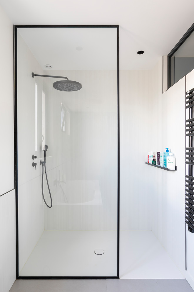 Imagen de cuarto de baño principal contemporáneo de tamaño medio con bañera encastrada, ducha a ras de suelo, baldosas y/o azulejos blancos, paredes blancas, lavabo bajoencimera, suelo blanco y ducha abierta