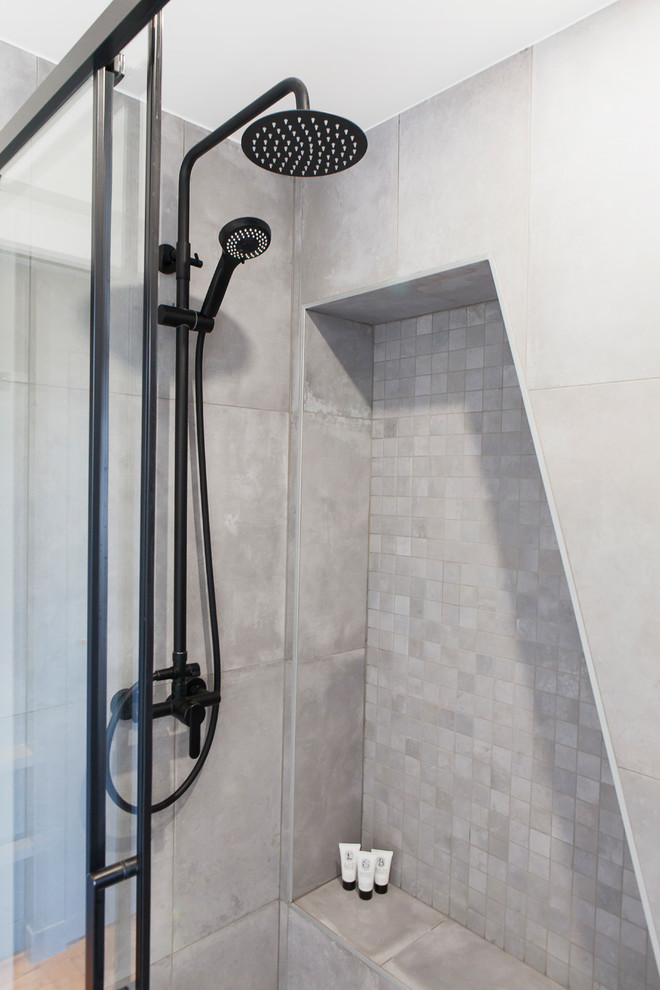 Inspiration för ett litet skandinaviskt grå grått badrum med dusch, med luckor med glaspanel, en dusch i en alkov, grå kakel, porslinskakel, grå väggar, klinkergolv i keramik, ett nedsänkt handfat, kaklad bänkskiva, grått golv och dusch med skjutdörr