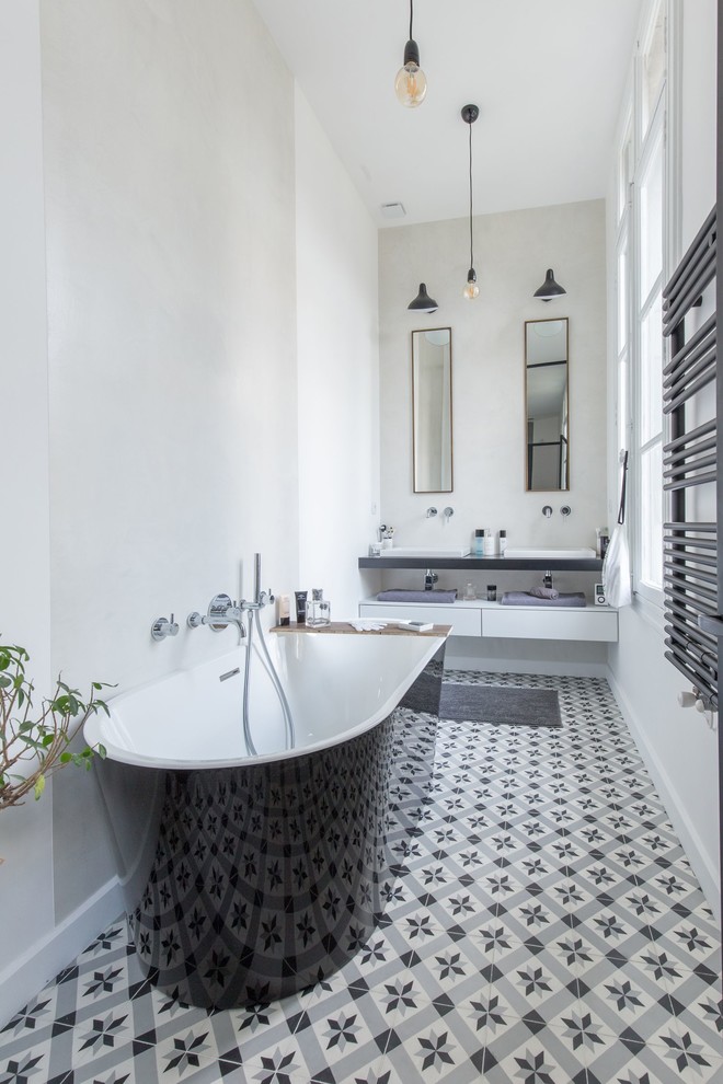 Diseño de cuarto de baño actual con bañera exenta, paredes grises, lavabo sobreencimera y suelo multicolor