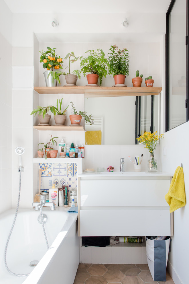 Foto di una stanza da bagno per bambini minimal con ante lisce, ante bianche, vasca ad angolo, piastrelle a mosaico, pareti bianche, pavimento marrone e top bianco