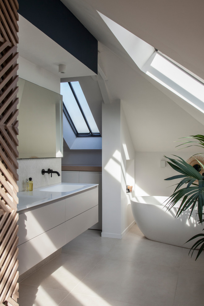 This is an example of an expansive contemporary ensuite bathroom in Paris with white cabinets, a freestanding bath, white walls, ceramic flooring, solid surface worktops, white worktops, double sinks, flat-panel cabinets, a submerged sink, a floating vanity unit, a two-piece toilet, beige tiles, ceramic tiles, beige floors, a sliding door, an enclosed toilet and an alcove shower.
